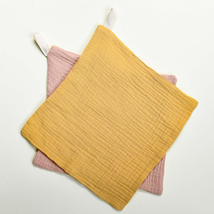 Pink and yellow set of organic cotton muslin washcloths.