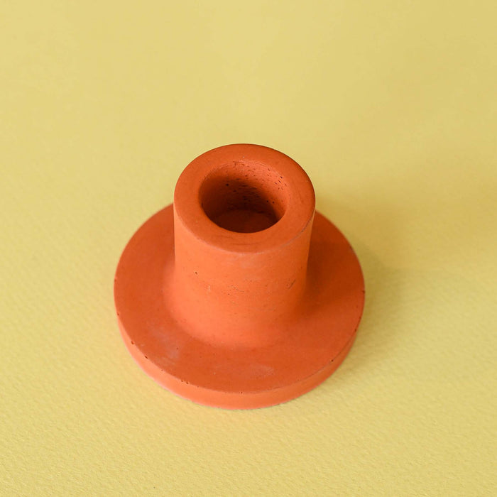 Handmade orange or poppy colored concrete candlestick holder.