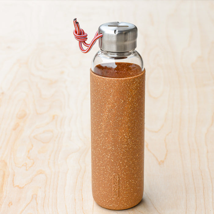 Glass water bottle in cork cover with steel lid and tie handle. Form Black and Blum.