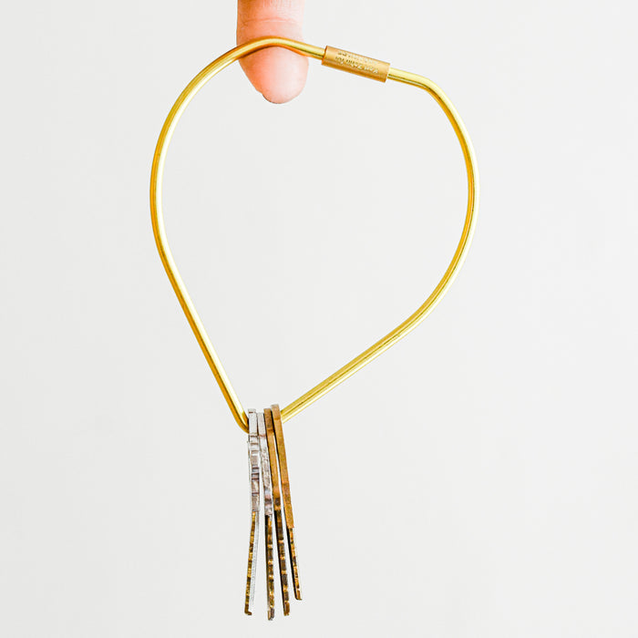 Brass drop key ring with screw closure. Hanging off finger.
