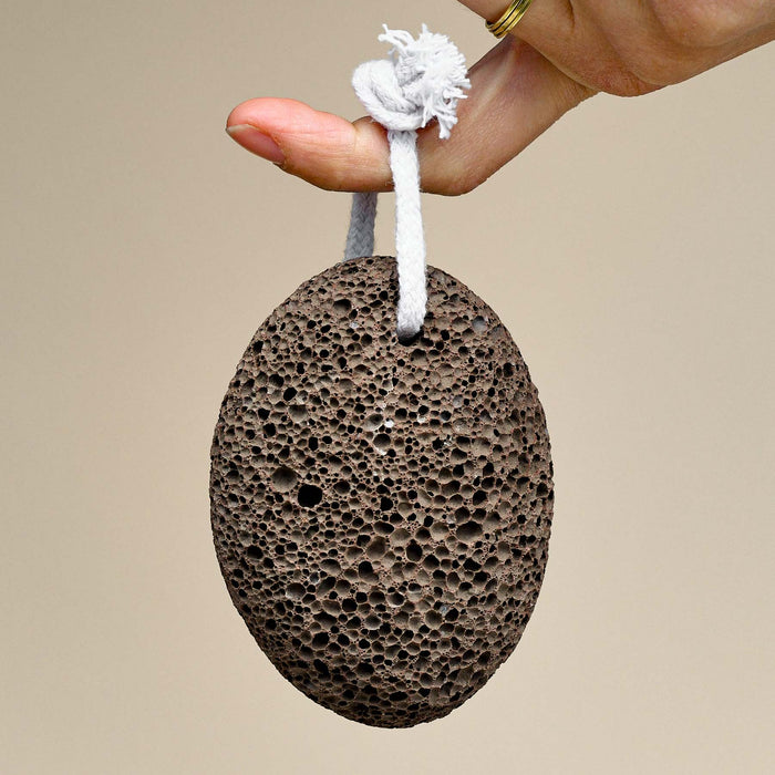 Finger holding medium sized pore lava stone from cotton loop.