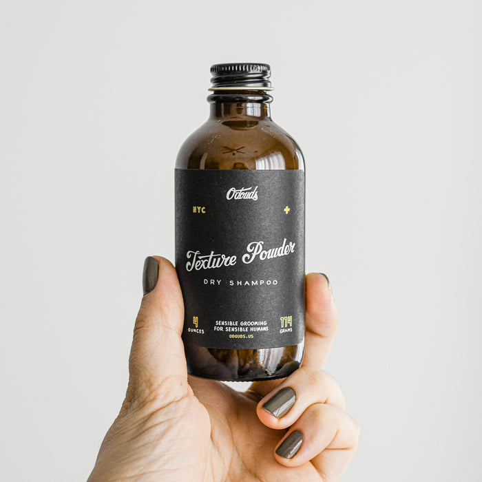 Odouds Dry shampoo texture powder in glass amber bottle.