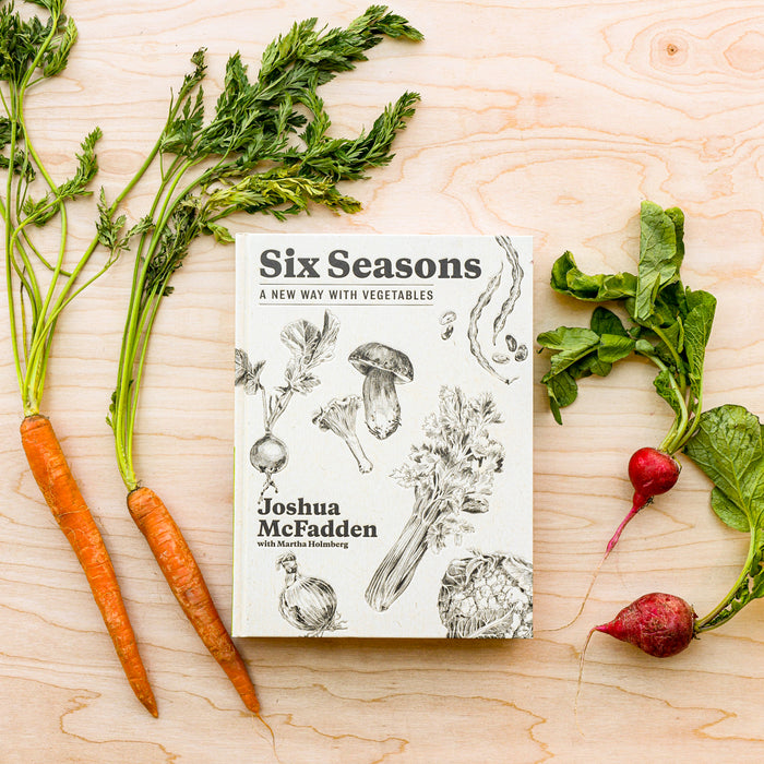 Six Seasons: A New Way with Vegetables cookbook surrounded by carrots and radishes.
