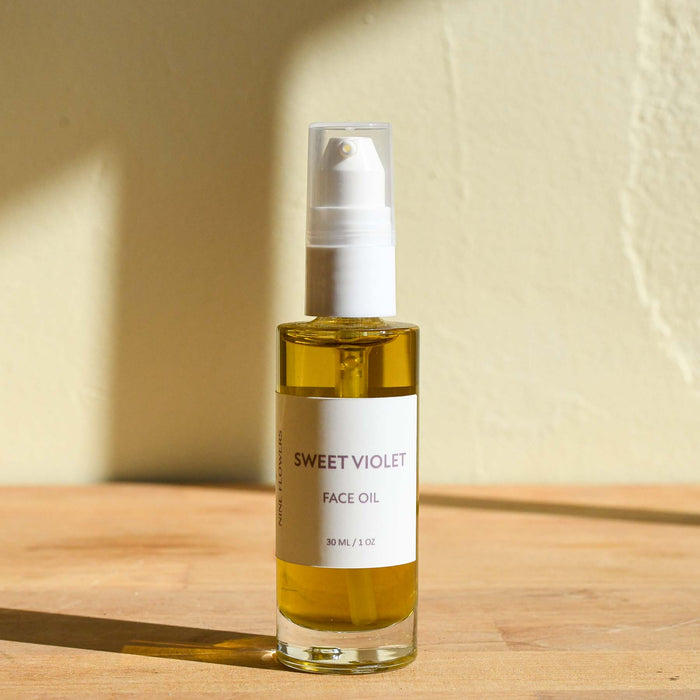 Glass clear bottle of sweet violet face oil by Heilbron Herbs. Made in Marshall, NC.