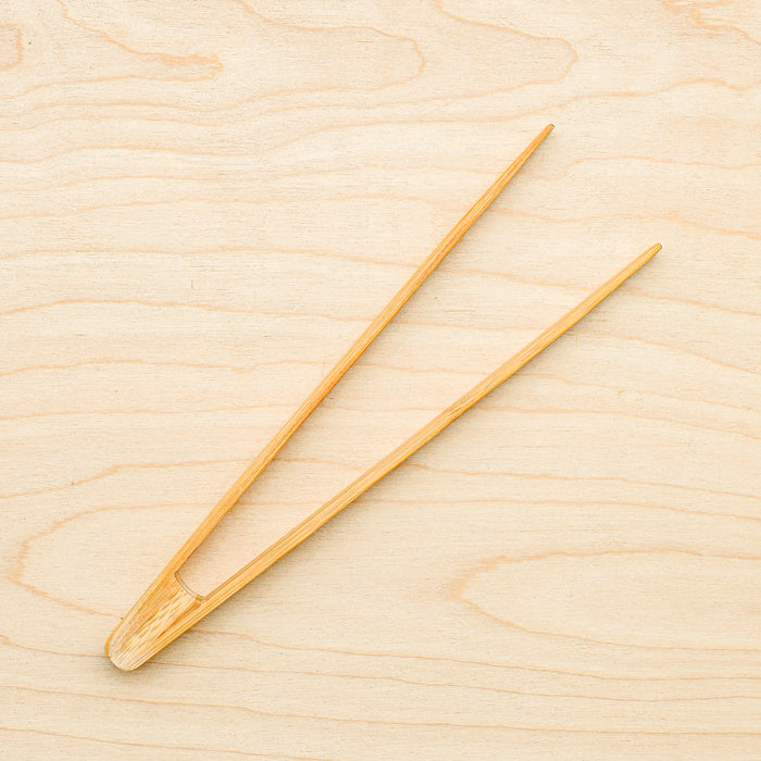 Bamboo toast tongs laying down.