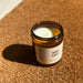 A candle in a reusable brown glass jar. It is scented with organic essential oils of lavender, cedar, bergamot, and vetiver.