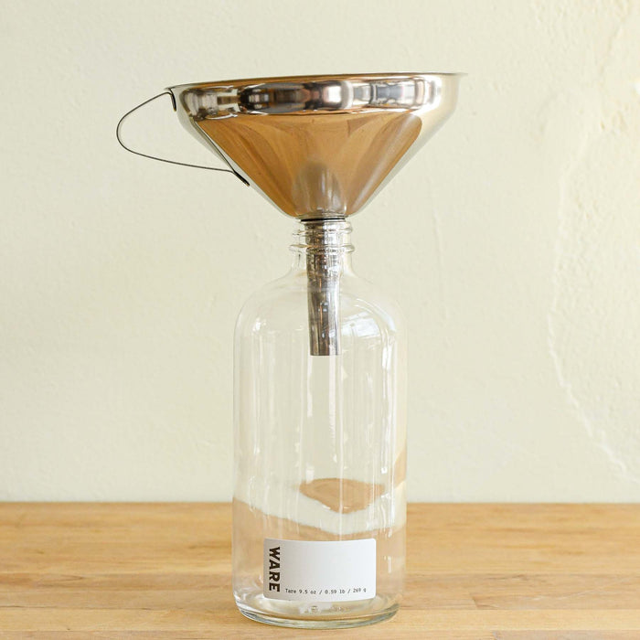 Stainless steel funnel set in narrow mouthed jar.