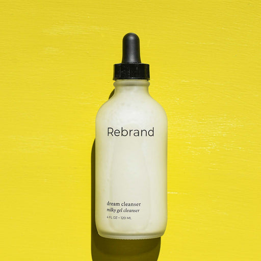 Glass dropper bottle on a milky cleanser from Rebrand. 