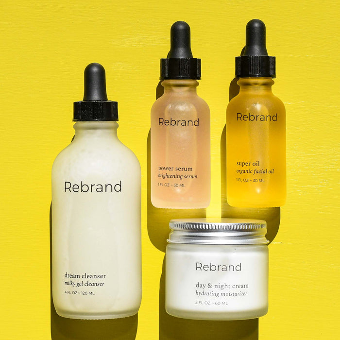 Rebrand facial collection of cleanser, moisturizer, serum, and oil.