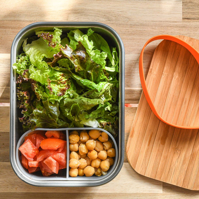 Inside large stainless steel lunchbox with silicone divider. Bamboo cutting board and orange silicone gasket. From Black and Blum. 