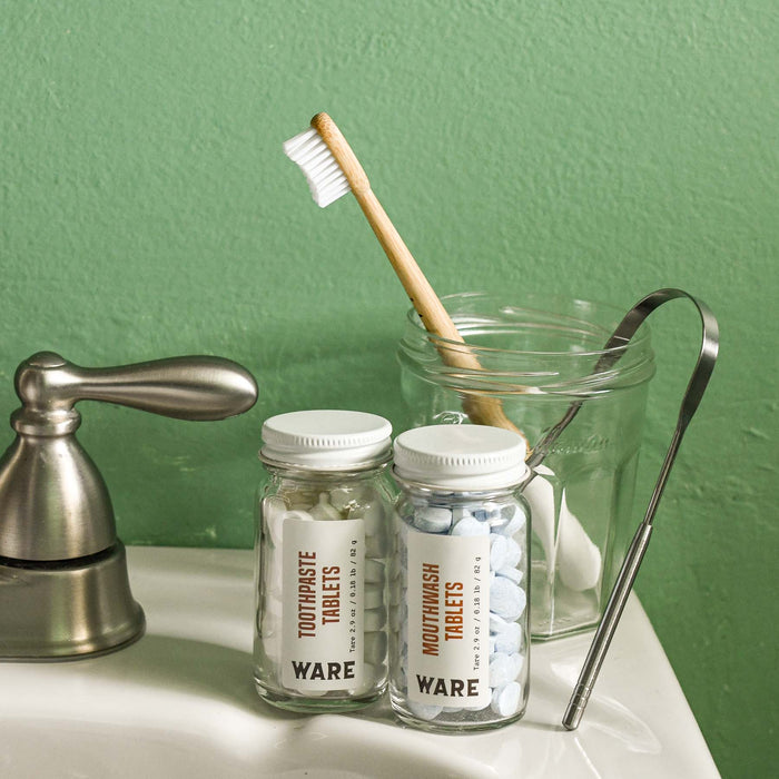 Bathroom featuring zero waste mouthwash and toothpaste tablets. Bamboo toothbrush and tongue scraper. 