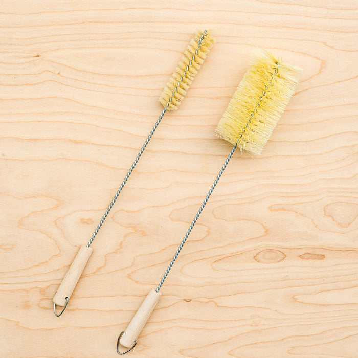 Agave fiber bottle brushes. One narrow, one standard size. Metal stems and hooks at the end.