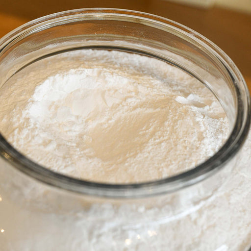 Bulk baking soda in a large glass jug without a lid.