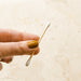 Single bamboo q-tip being held by a hand.
