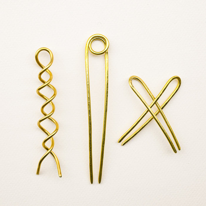 Various handmade brass bun pins for hair. 
