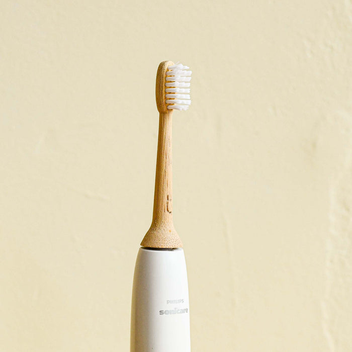 Bamboo electric toothbrush head attached to a Philips Sonicare toothbrush base.