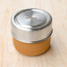 Glass lunch bowl with silicone lid in a metal and wood fiber container. From Black and Blum. 