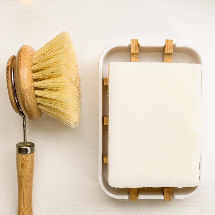 Zero-waste solid dish soap on bamboo grid soap tray with a zero waste replaceable dish brush. 