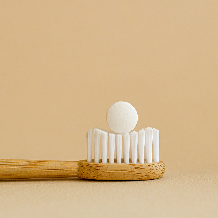 Toothpaste tabs in comparison to toothbrush head. 