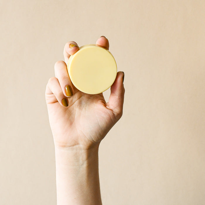 Hand holding the original Nopalera lotion bar. 