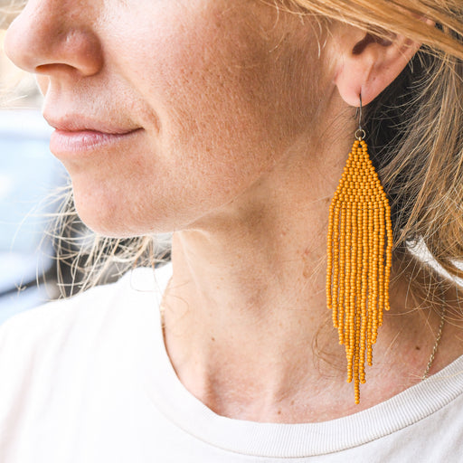Person wearing honey cluster beaded earrings. Made in Asheville, NC.