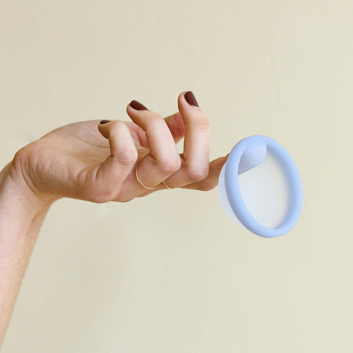 Light blue silicone regular sized reusable menstrual disc. Finger gripper. From Saalt. 