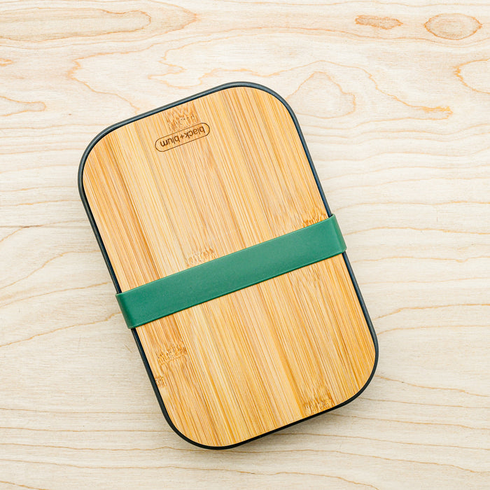 Stainless steel sandwich box with bamboo cutting board lid and silicone gasket in olive. From Black and Blum. 