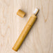 TrBamboo toothbrush case with toothbrush sticking out and cap sitting beside case. From Truthbrush.