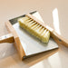 Wood and metal magnetic dust broom with hanging loop.